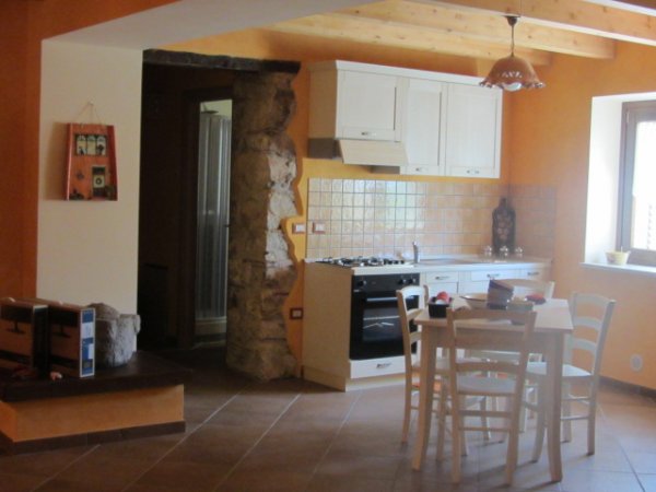 Cucina rustica con tavolino e sedie.
