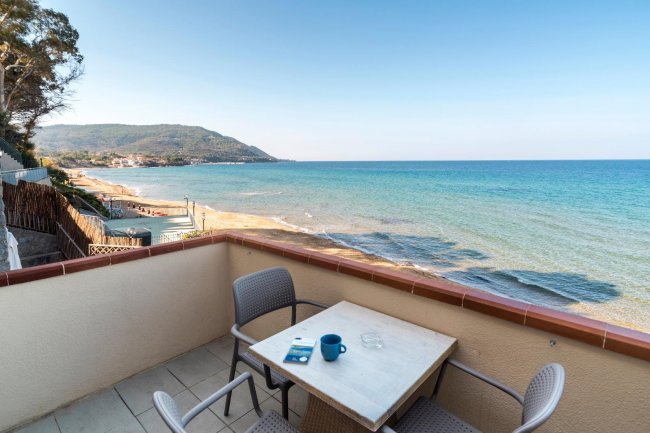 Balcone con tavolino e vista panoramica sulla spiaggia.
