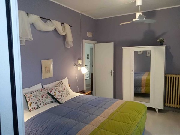 Camera con letto matrimoniale e armadio bianco.