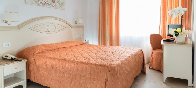 Camera da letto con letto arancione e scrivania.
