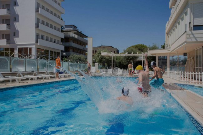 Persone che si tuffano in una piscina.
