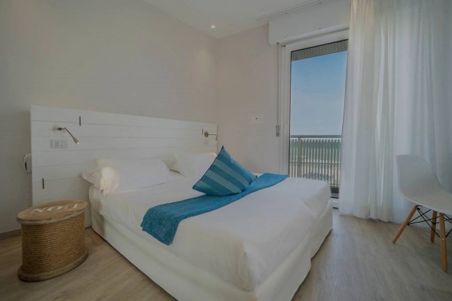 Camera con letto matrimoniale e balcone.