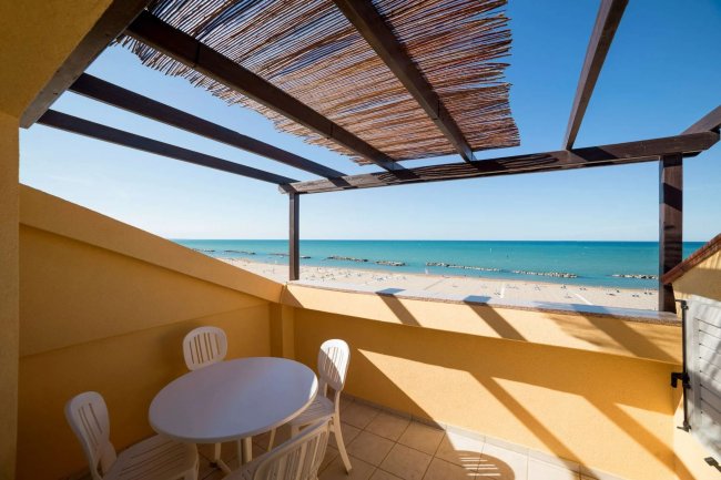 Terrazza vista mare con tavolo e sedie.