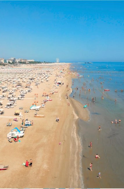 Vista aerea di una spiaggia affollata di bagnanti.
