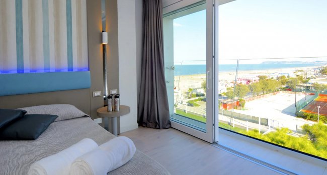 Camera con vista mare e spiaggia dal balcone.