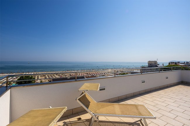 Terrazza con vista mare e due lettini prendisole.