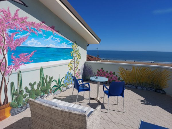 Terrazza con vista mare e murales colorato.