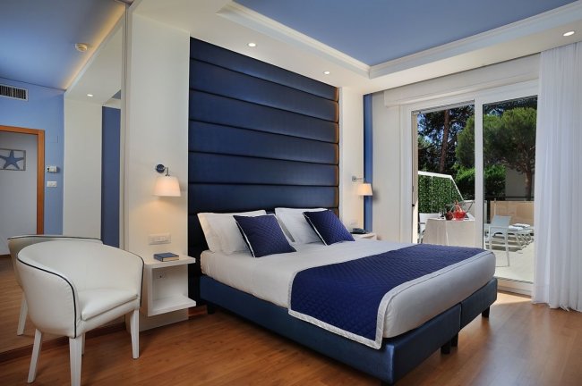 Camera da letto elegante con arredi blu e bianchi.