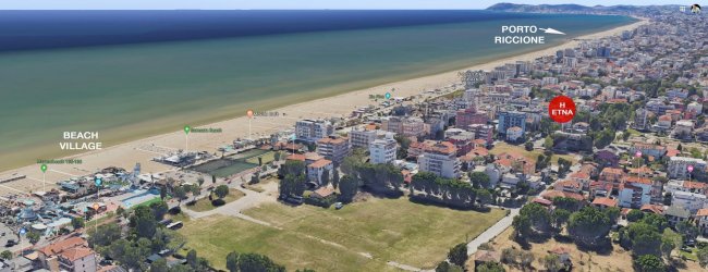 Panorama aereo di una città costiera con spiaggia.