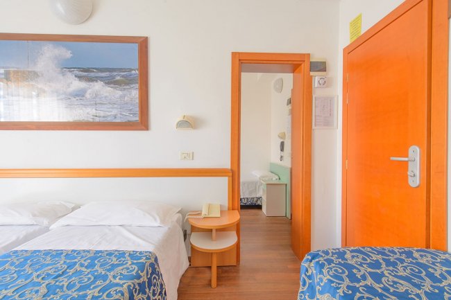 Camera con letto singolo, quadro marino e porte arancioni.