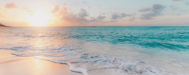 Una spiaggia al tramonto con onde delicate.