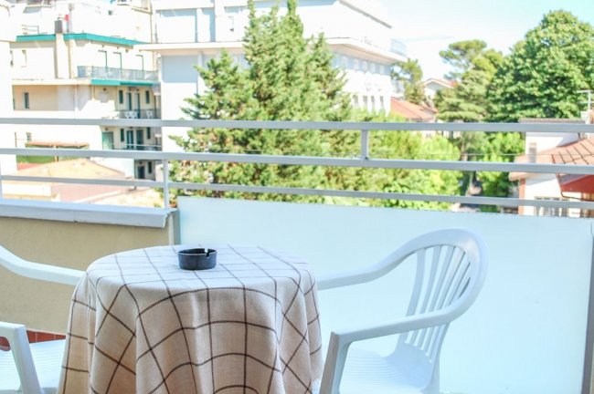 Balcone con tavolo, sedia e vista.