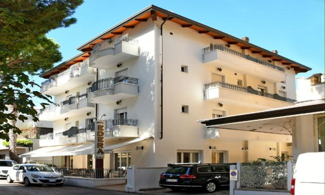 Edificio bianco a quattro piani con balconi.
