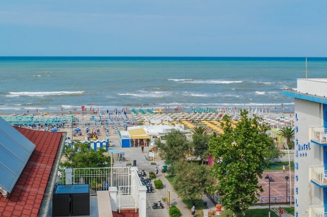 Vista sulla spiaggia affollata e mare azzurro.