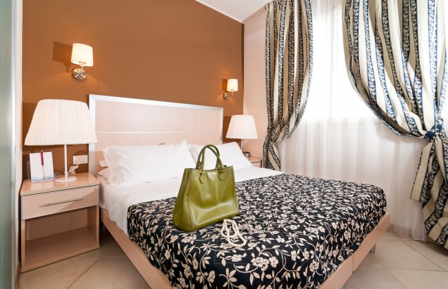 Una camera da letto con letto matrimoniale e borsa verde.