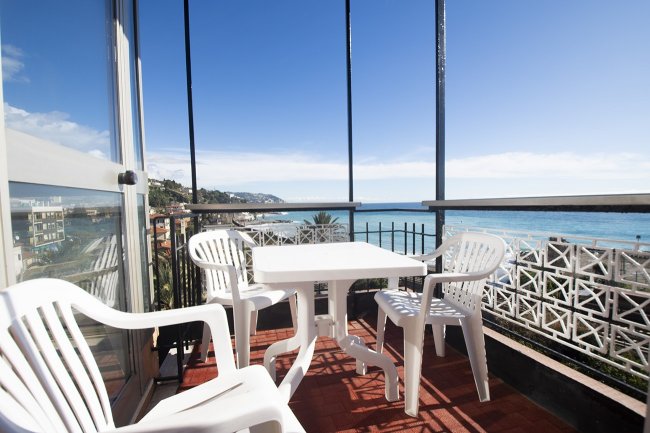 Terrazza con sedie bianche e vista mare.