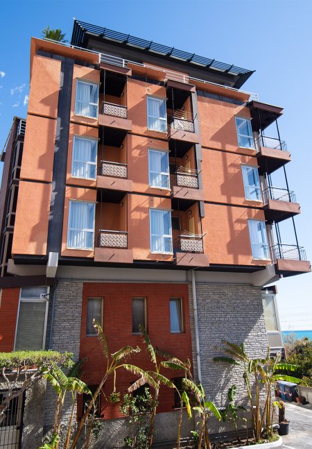 Edificio moderno con balconi e pareti arancioni.