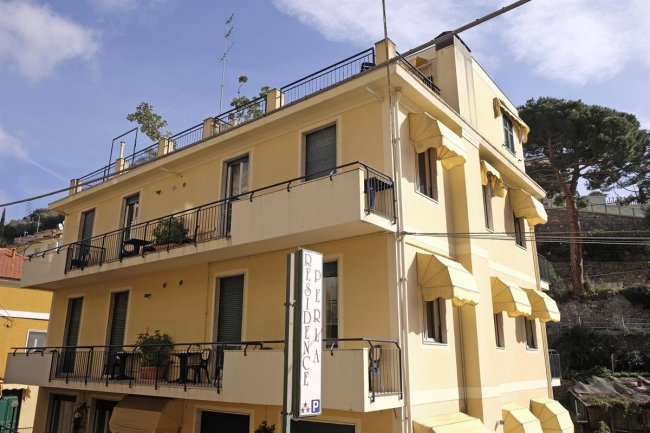 Edificio giallo con balconi e tendoni.