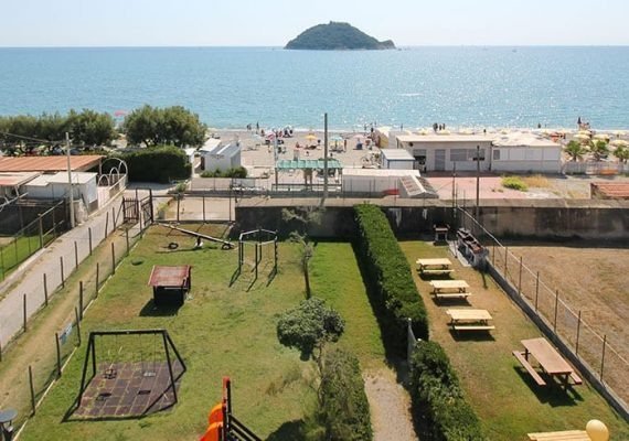 Area giochi e tavoli da picnic vicino al mare.