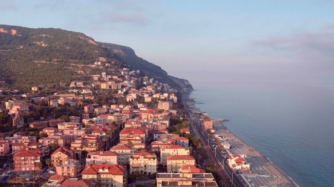Vista aerea di una città costiera e colline.