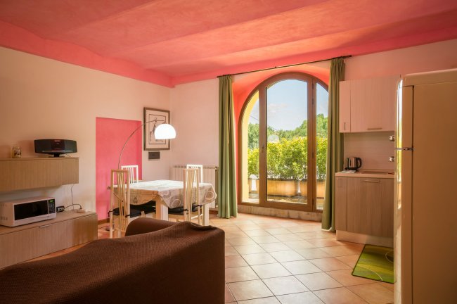 Interno luminoso con pareti rosa e grande finestra.