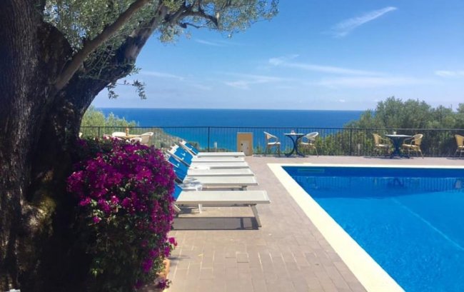 Lettini a bordo piscina con vista mare.