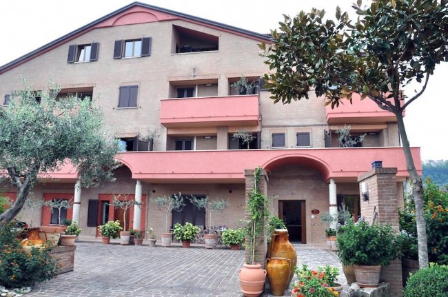 Facciata edificio con balconi e piante.