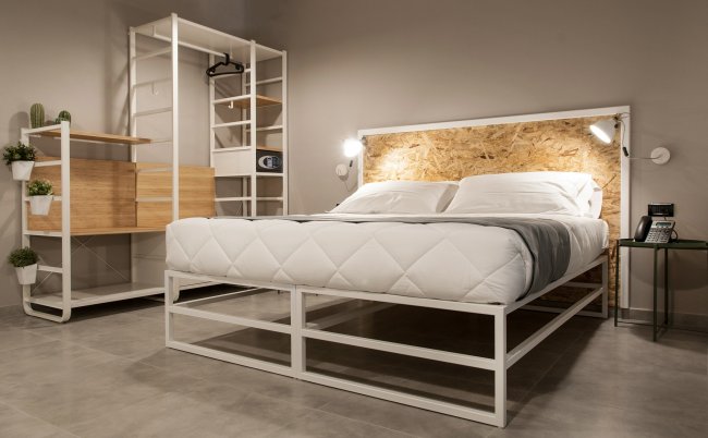 Camera da letto con letto moderno e scaffali aperti.