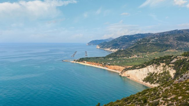 Vista costiera con mare e colline verdi.