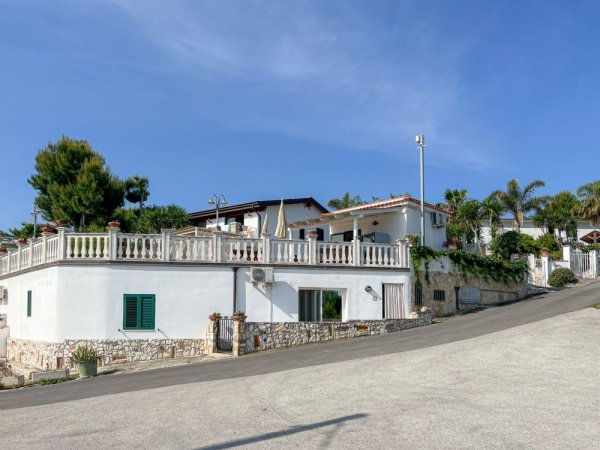 Casa bianca su una collina con cielo blu.
