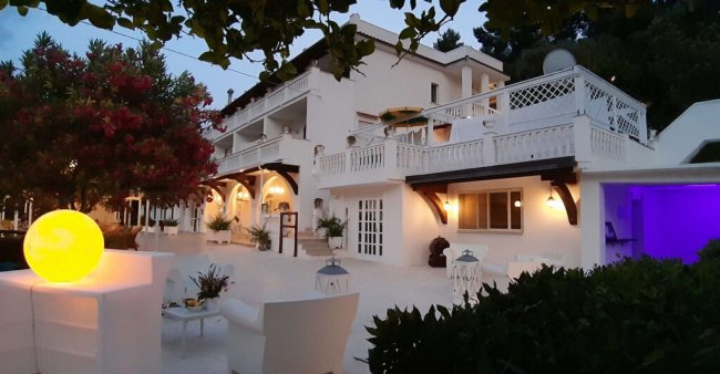 Edificio bianco con divani all'aperto.