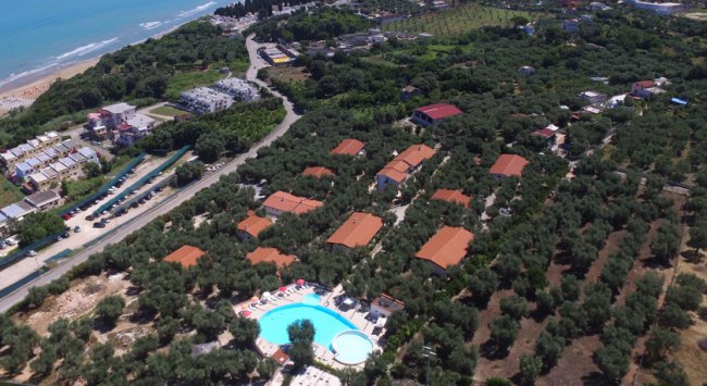 Vista dall'alto di un complesso con piscina e mare.