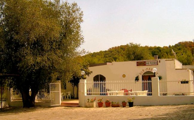 Edificio bianco con terrazza e cancello bianco.
