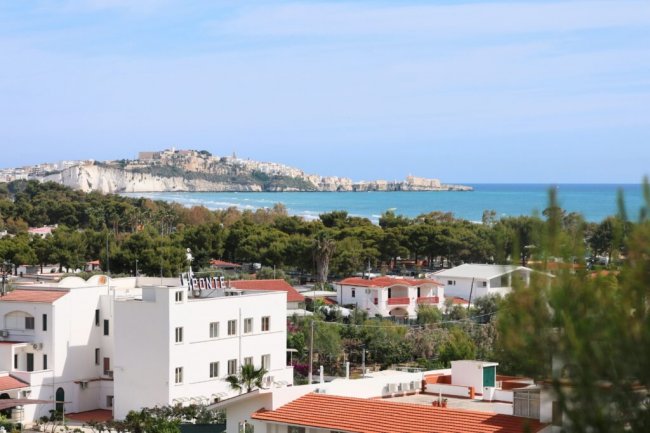 Vista panoramica di edifici bianchi e mare in lontananza.