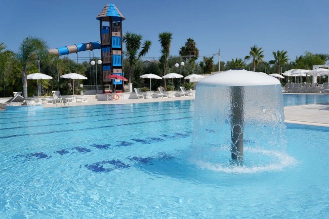Piscina con fontana e scivolo blu.