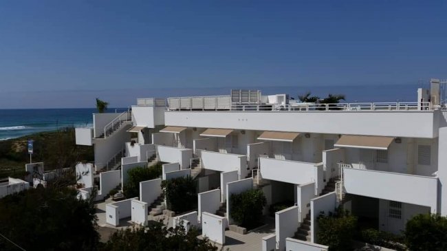 Edificio bianco a più livelli vicino al mare.