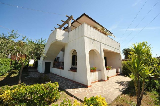 Villa bianca con terrazza e giardino.