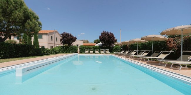 Piscina con lettini e ombrelloni.