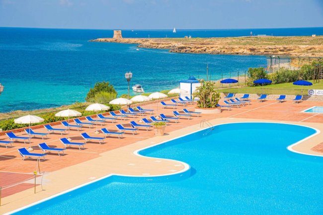 Piscina con lettini, vista mare azzurro.