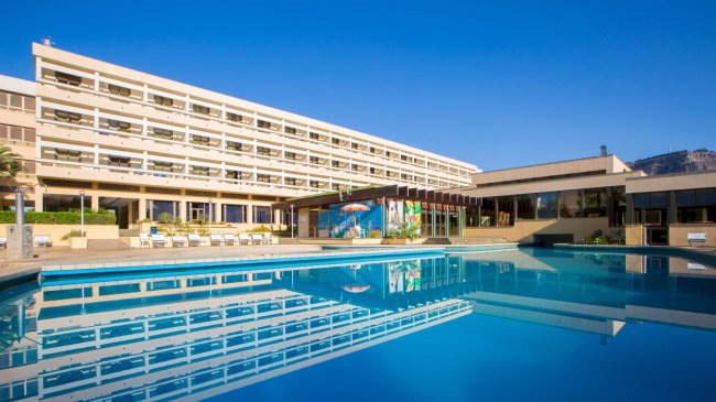 Edificio con piscina all'aperto e cielo blu.
