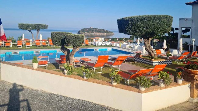 Piscina con lettini e vista sull'isola.