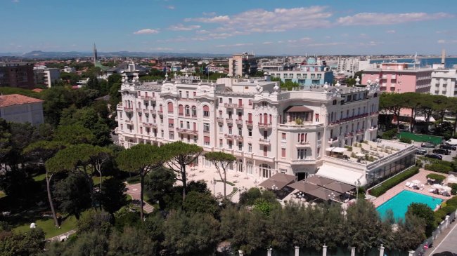 Grande edificio bianco con piscina e giardino.