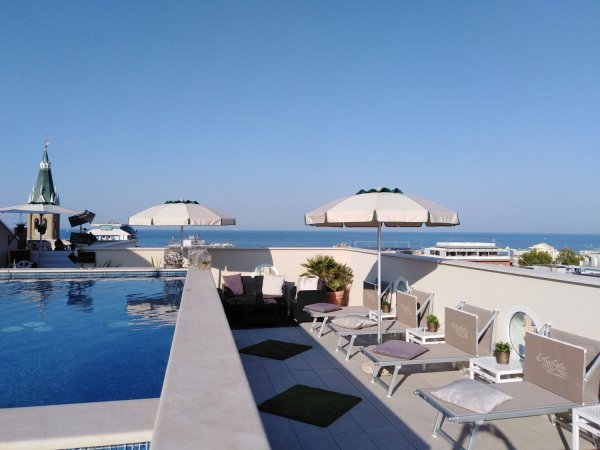 Terrazza panoramica con piscina e sedie a sdraio.
