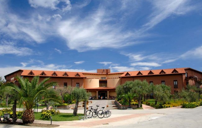 Edificio con tetto in tegole e biciclette nel giardino frontale.