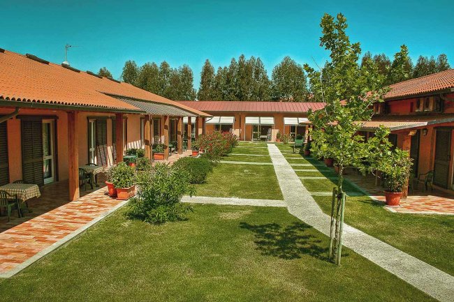 Complesso residenziale con cortile e vialetti erbosi.