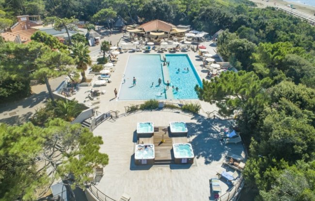 Piscina con jacuzzi tra gli alberi.