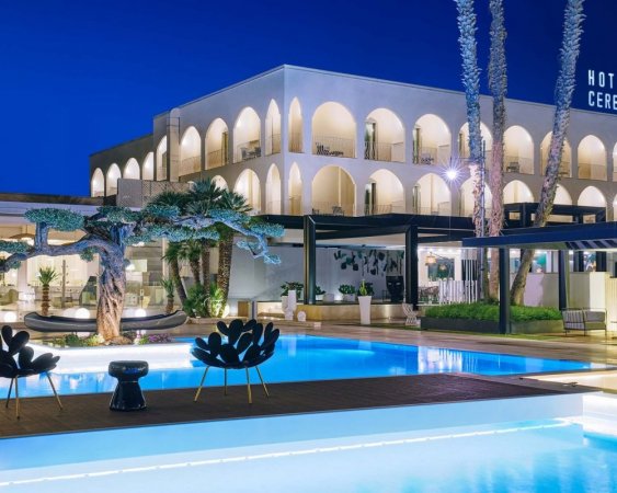 Hotel di notte con piscina illuminata.