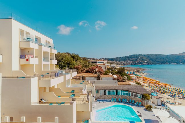 Vista di un hotel con piscina e mare.