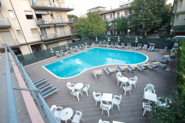 Vista dall'alto di una piscina circondata da sedie e tavoli.