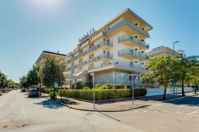 Hotel moderno a più piani in strada soleggiata.